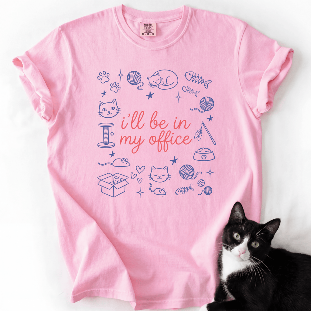 Blossom funny cat t shirt with I'll be in my office text and pastel cat themed doodle design, shown flat with a black cat beside it