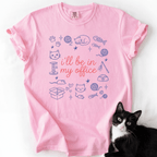 Blossom funny cat t shirt with I'll be in my office text and pastel cat themed doodle design, shown flat with a black cat beside it