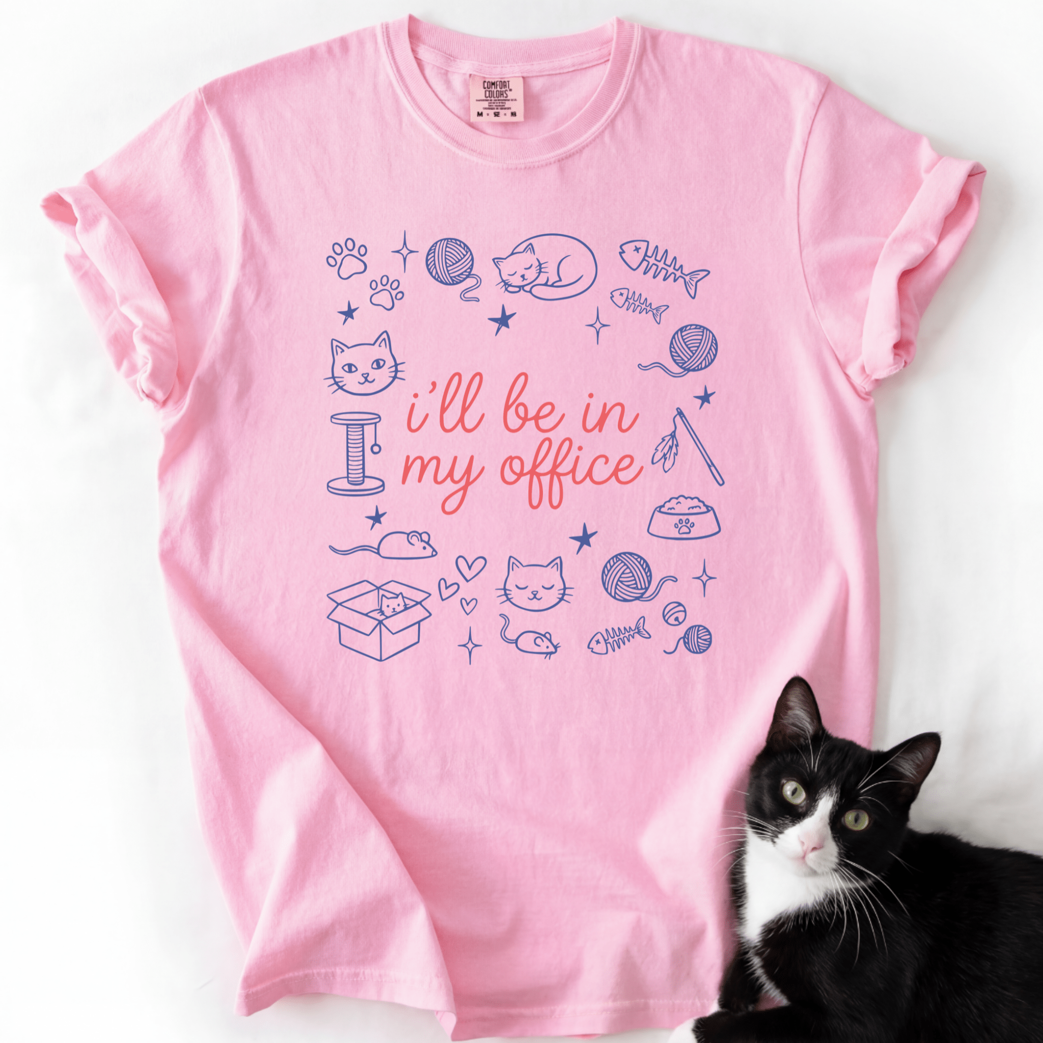 Blossom funny cat t shirt with I'll be in my office text and pastel cat themed doodle design, shown flat with a black cat beside it