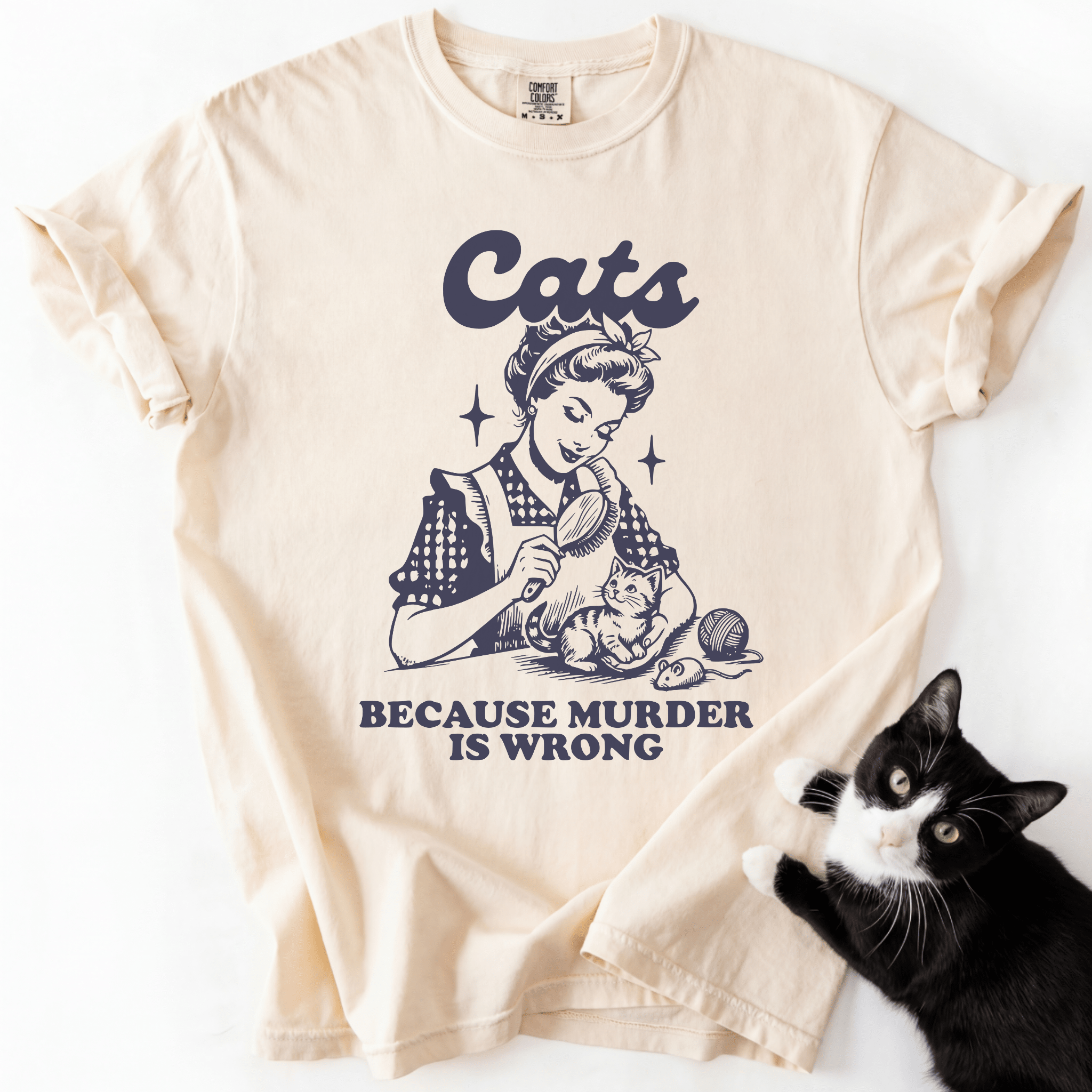 Cream cat t shirt with vintage black cat illustration and the phrase “Cats Because Murder Is Wrong”