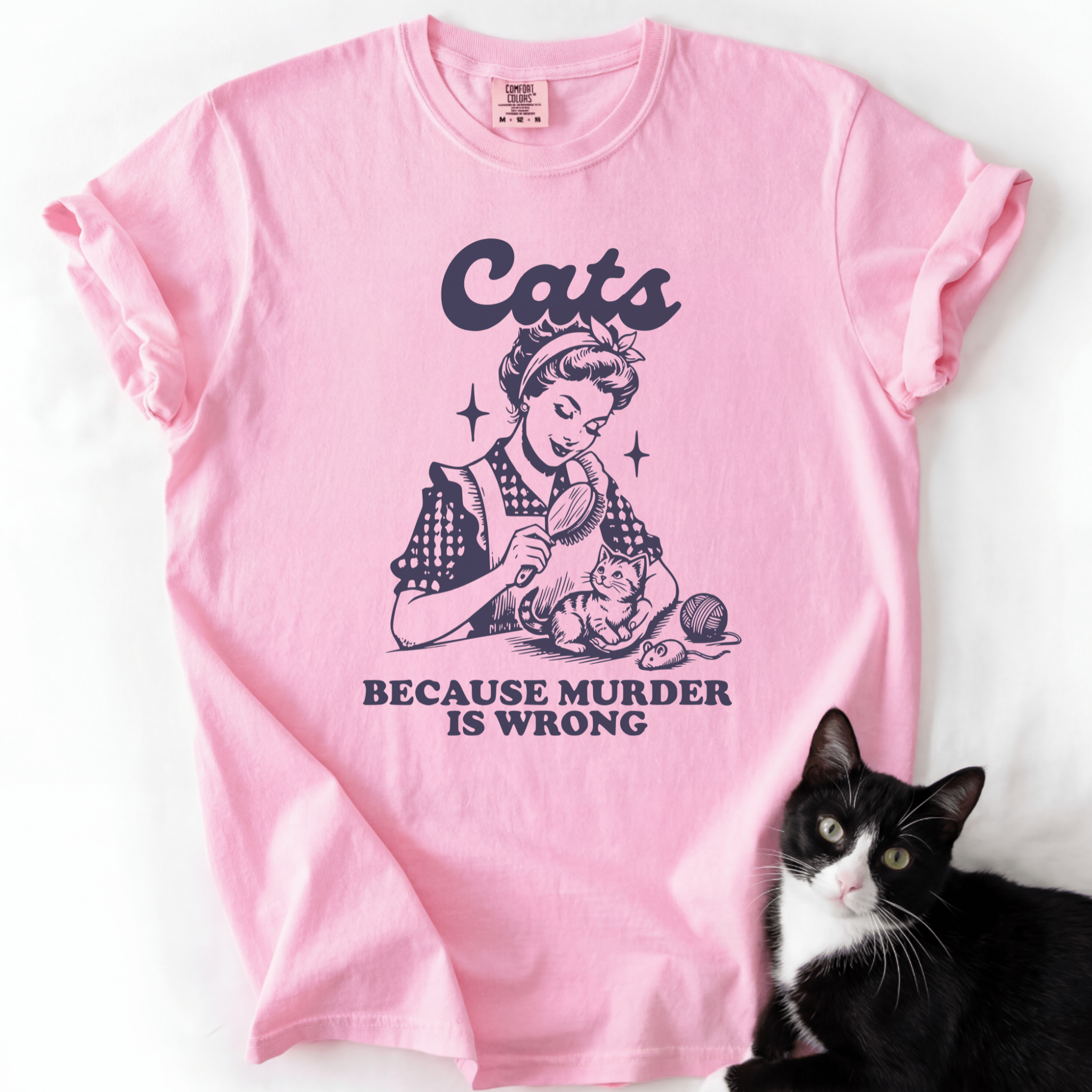 Pink cat t shirt with illustrated black cat design and “Cats Because Murder Is Wrong” text