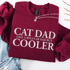 Maroon embroidered cat dad sweatshirt folded flat with CAT DAD COOLER text
