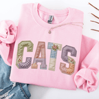 Light pink graphic sweatshirt with CATS faux patchwork lettering folded flat
