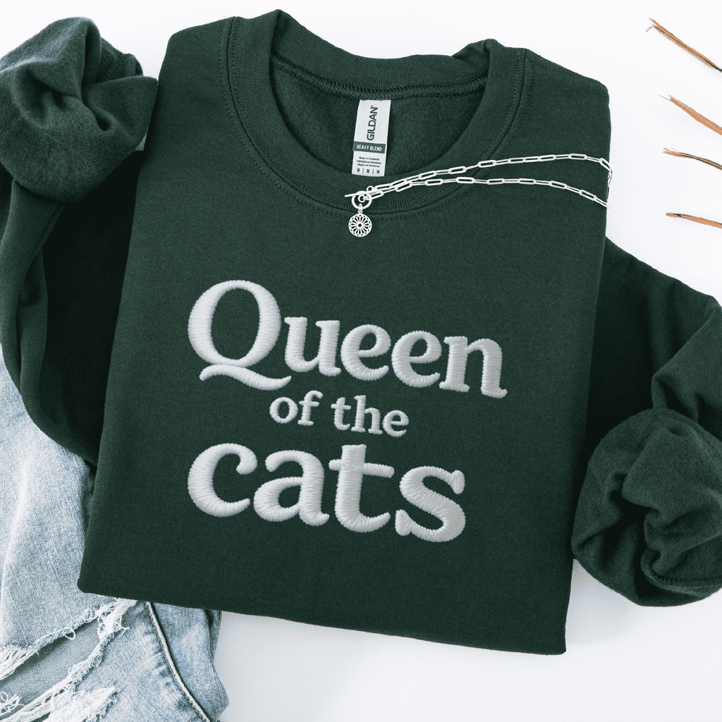 Forest Green embroidered sweatshirt with Queen of the Cats text shown folded