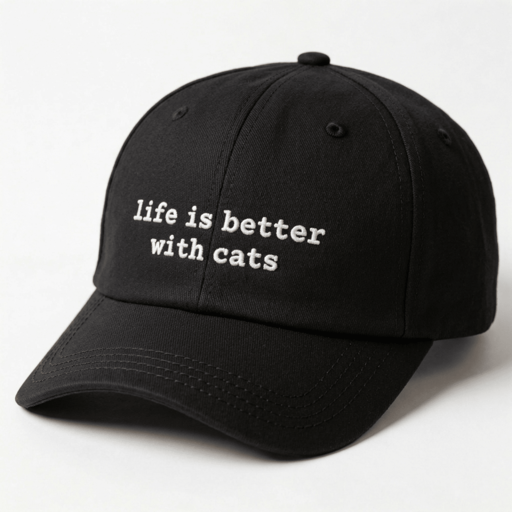 Angled front view of a black embroidered cap with life is better with cats text on the front