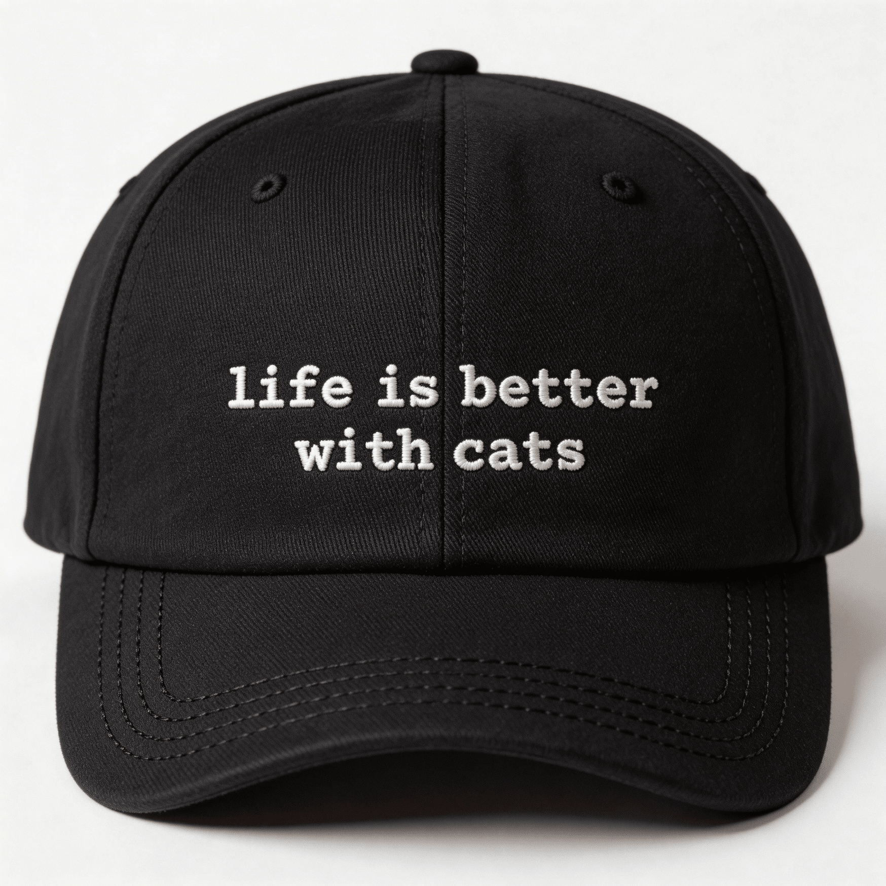 Front view of a black embroidered cap with the phrase life is better with cats in white lettering