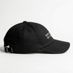 Angled front view of a black embroidered cap with cats are good for the soul text on the front