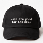 Front view of a black embroidered cap with the phrase cats are good for the soul in white lettering