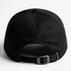 Back view of a black embroidered cap with adjustable strap and metal buckle