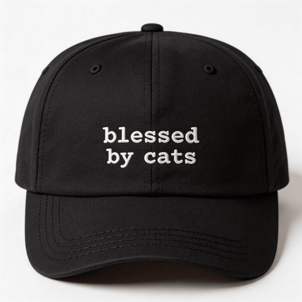 Black embroidered cap with the phrase blessed by cats stitched in white on the front