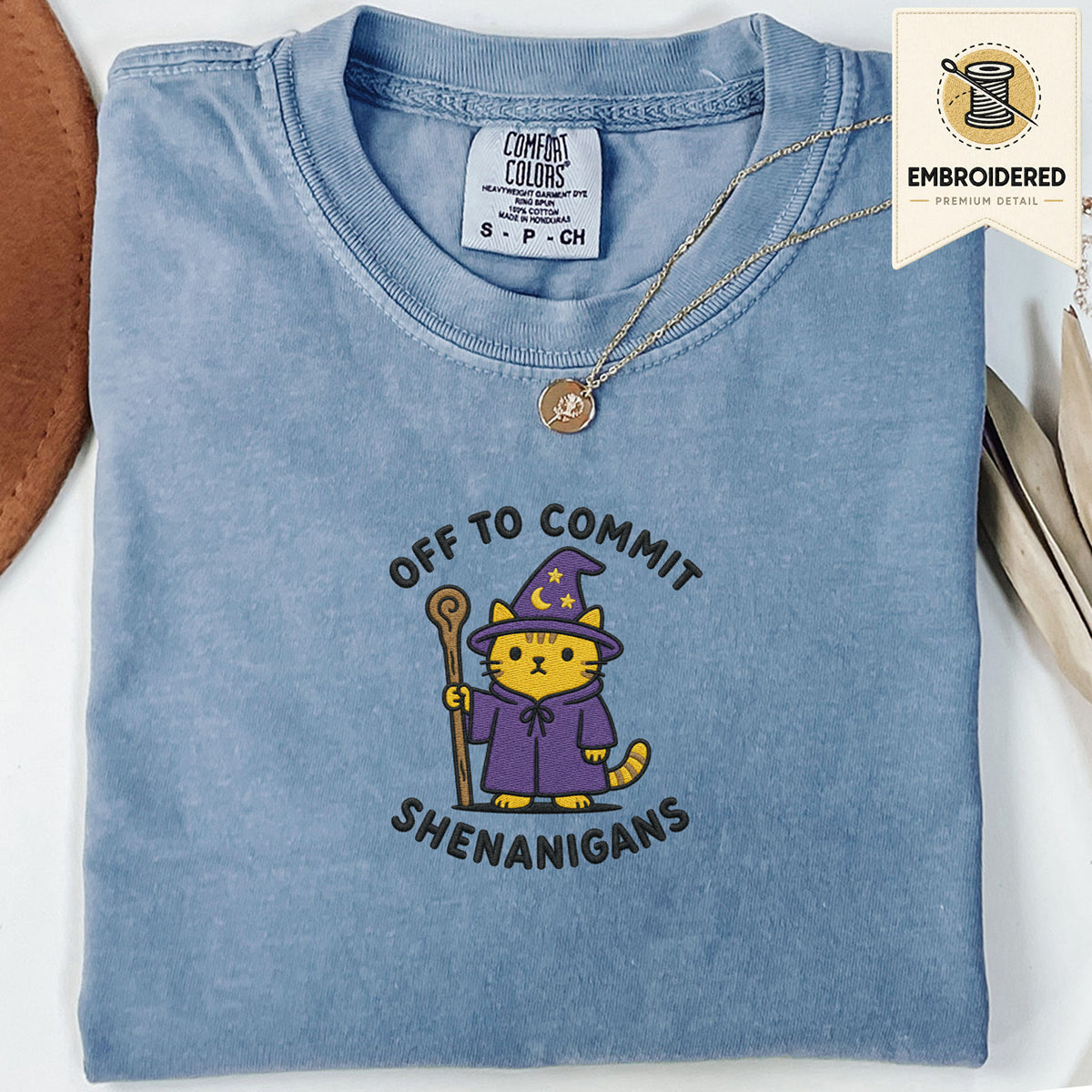 Blue jean embroidered funny cat t shirt with Commit Shenanigans text and mischievous cat design