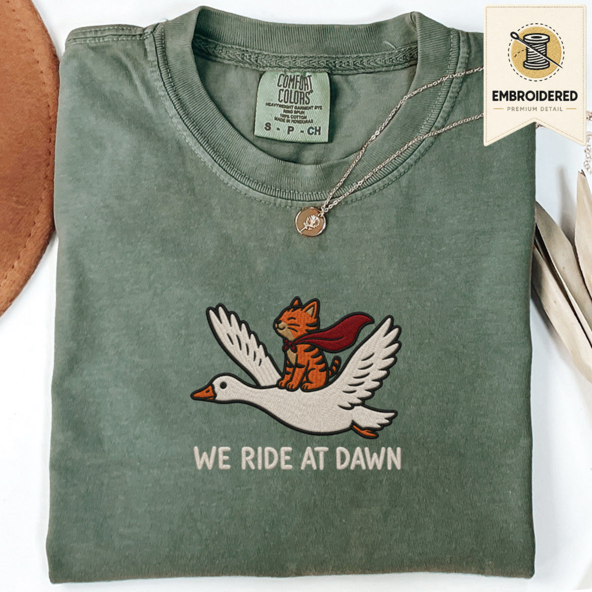 Moss green embroidered funny cat t shirt with We Ride At Dawn orange cat graphic