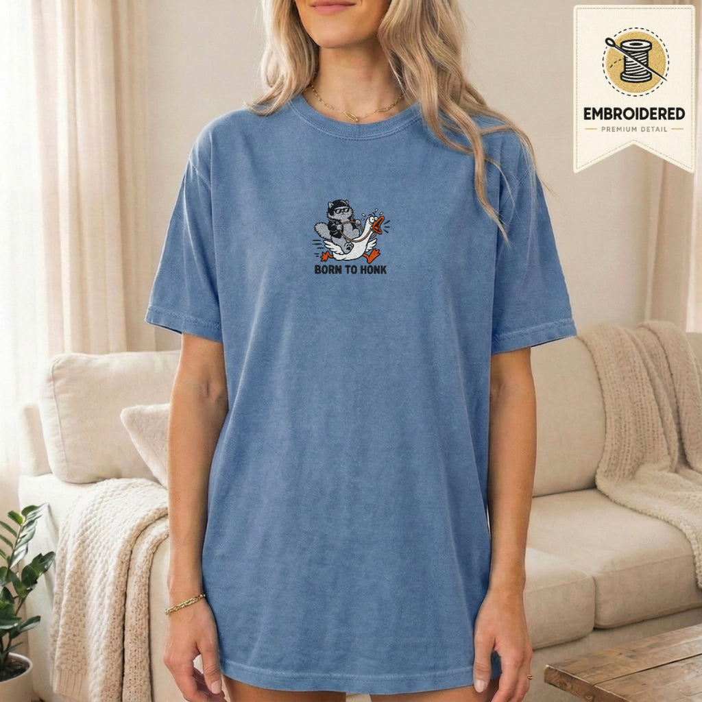 Woman wearing a blue jean embroidered funny cat t shirt with Born To Honk cat design while standing indoors