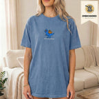 Woman wearing a blue jean embroidered funny cat t shirt with This Is An Outrage cat design while standing indoors