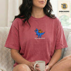 Woman wearing a crimson embroidered funny cat t shirt with This Is An Outrage cat design while standing indoors