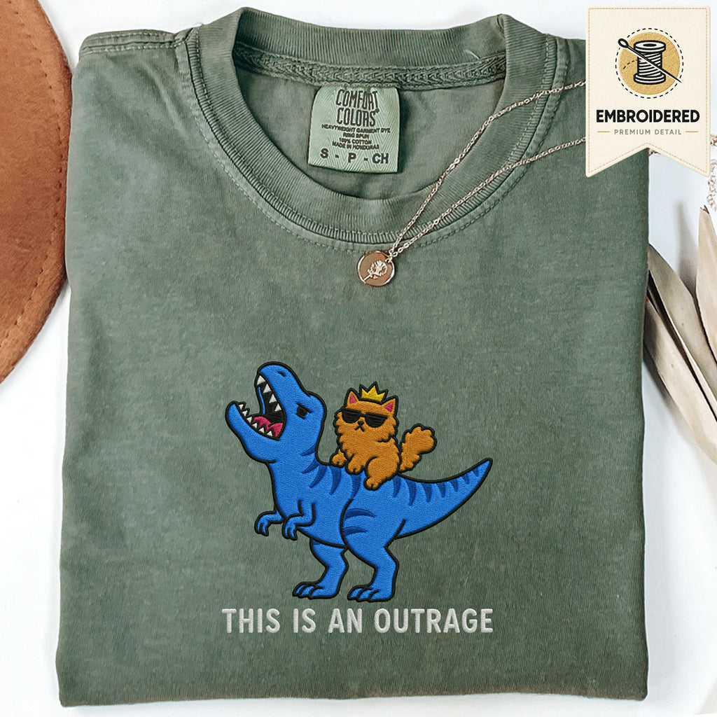 Moss green embroidered funny cat t shirt with This Is An Outrage text and blue cat carrying orange cat design