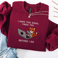 Maroon embroidered cat sweatshirt with orange cat at a laptop, I Hope This Email Finds You Before I Do text, flat lay