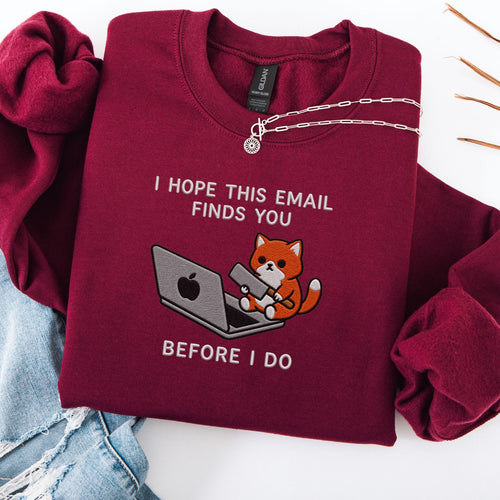Maroon embroidered cat sweatshirt with orange cat at a laptop, I Hope This Email Finds You Before I Do text, flat lay