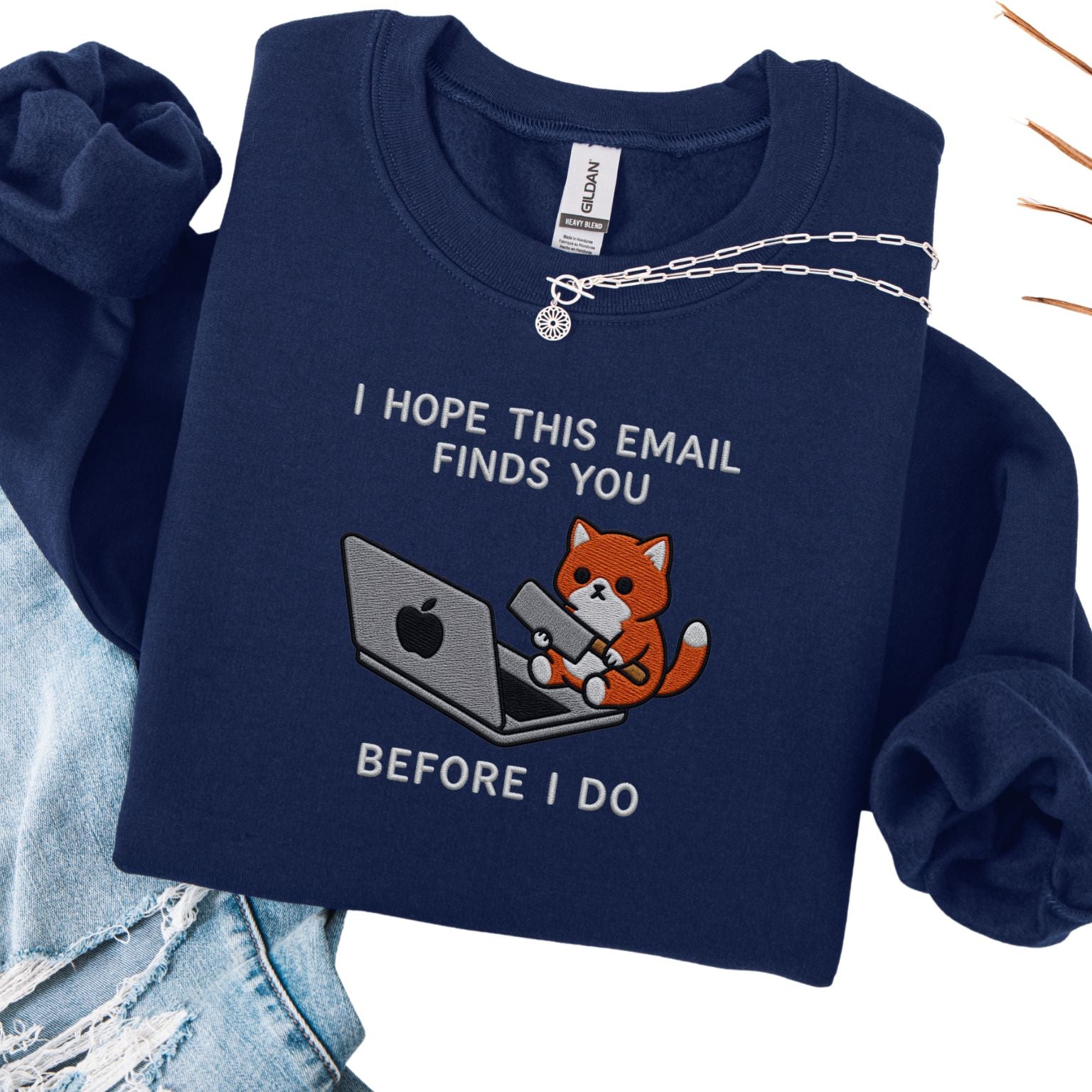 Navy embroidered cat sweatshirt with orange cat at a laptop, I Hope This Email Finds You Before I Do text, flat lay