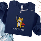Navy embroidered cat sweatshirt with heroic orange tabby in red cape holding sword aloft, Purrtector text, flat lay