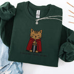 Forest green embroidered cat sweatshirt with medieval orange tabby in red cape holding a sword, I Require Treats M'Lord text, flat lay