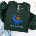 Forest green embroidered cat sweatshirt with crowned orange cat riding a T-Rex, This Is An Outrage text, flat lay