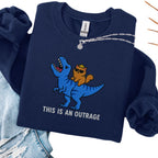 Navy embroidered cat sweatshirt with crowned orange cat riding a T-Rex, This Is An Outrage text, flat lay