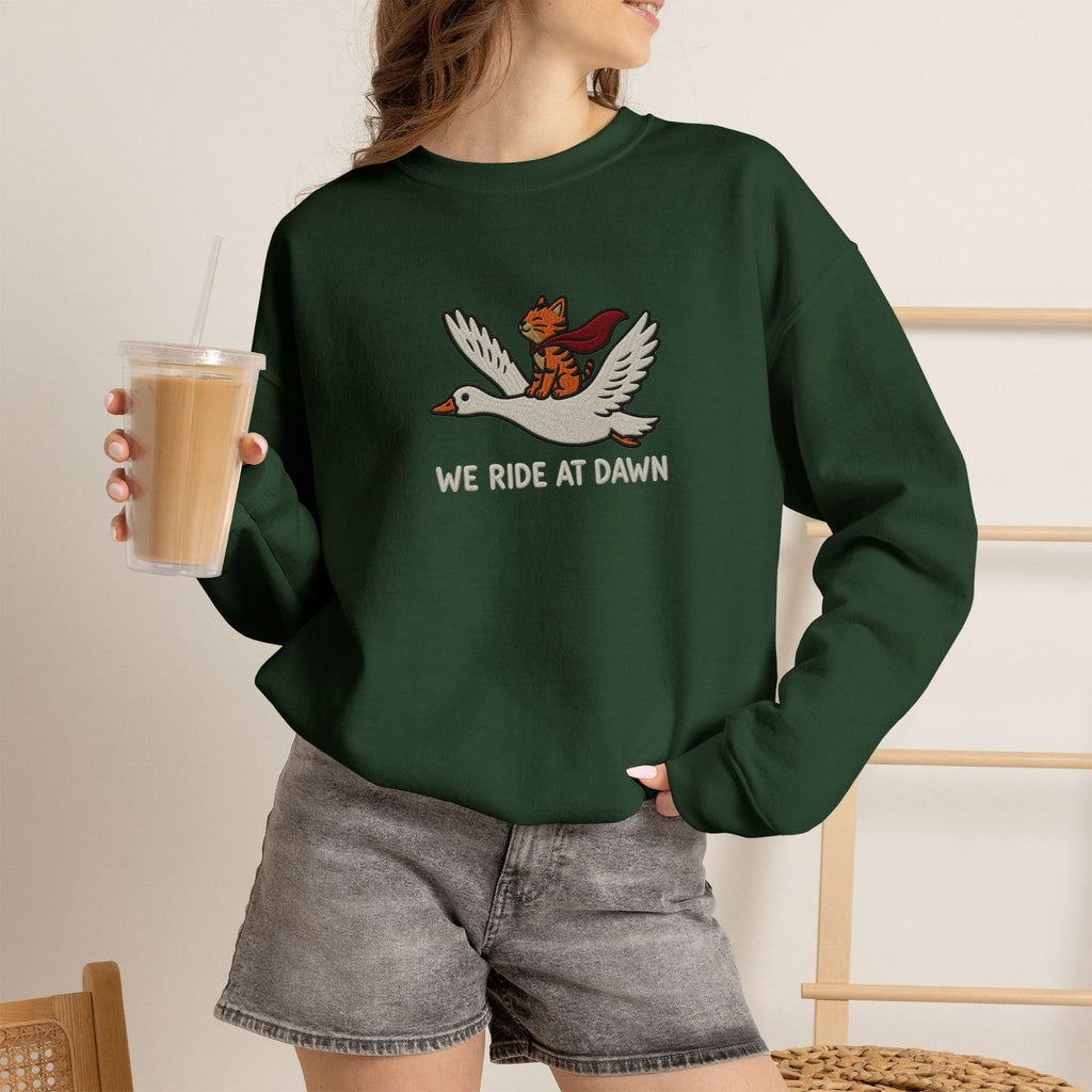 Model wearing forest green We Ride At Dawn embroidered cat sweatshirt, holding iced coffee