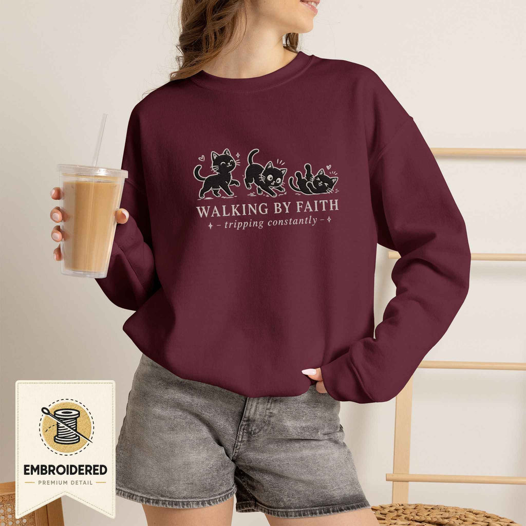 Woman wearing a maroon embroidered Walking by Faith cat sweatshirt