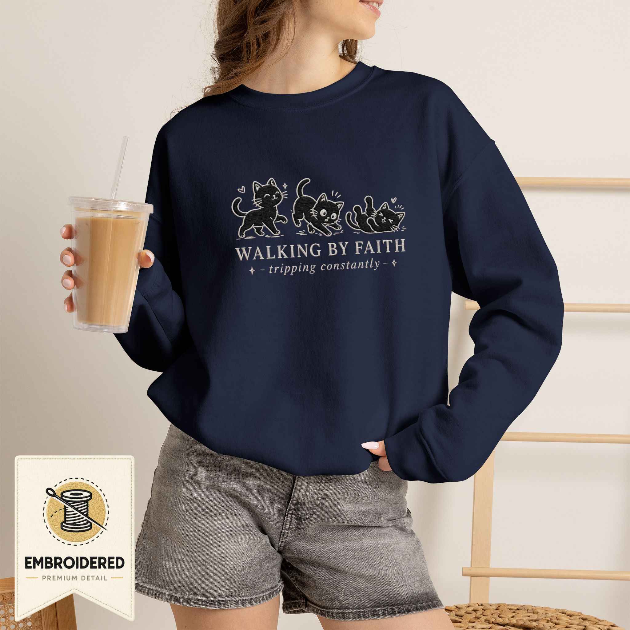 Woman wearing a navy embroidered Walking by Faith cat sweatshirt