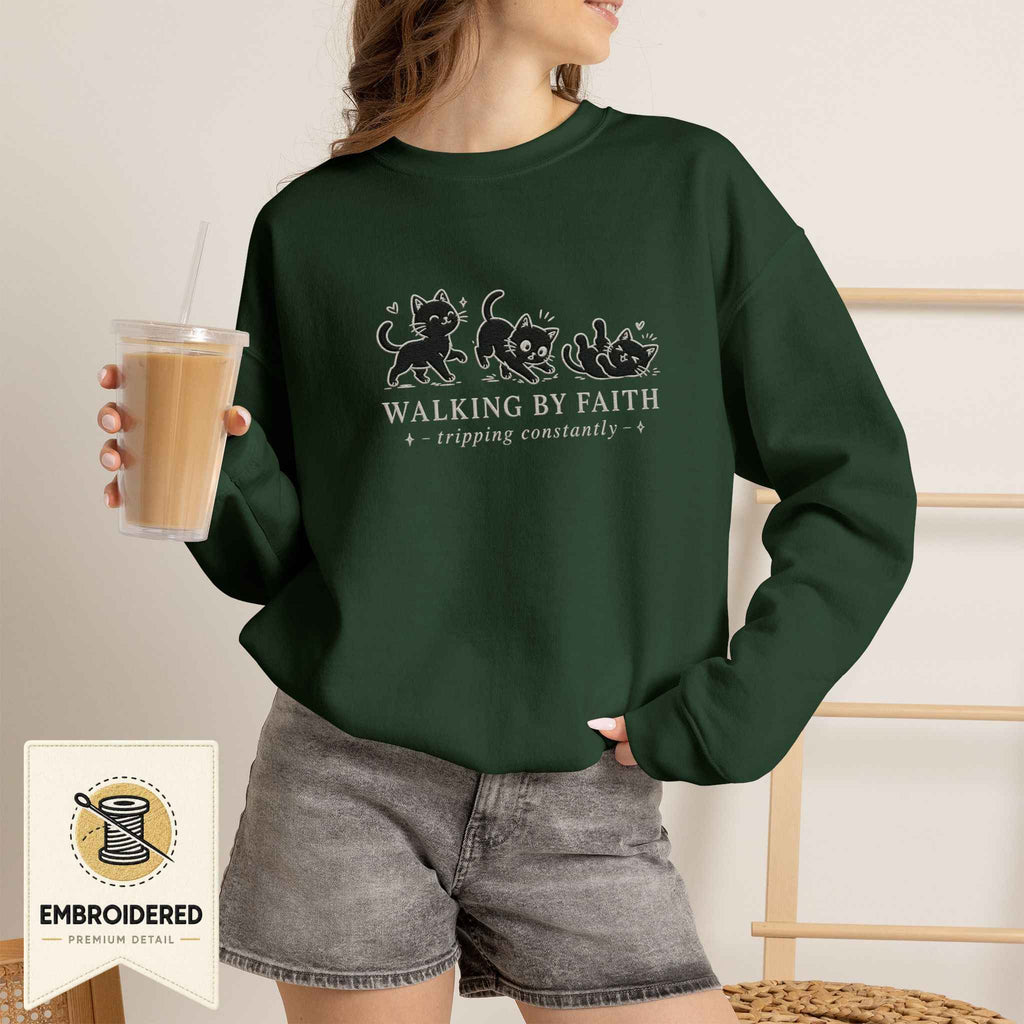 Woman wearing a forest green embroidered Walking by Faith cat sweatshirt