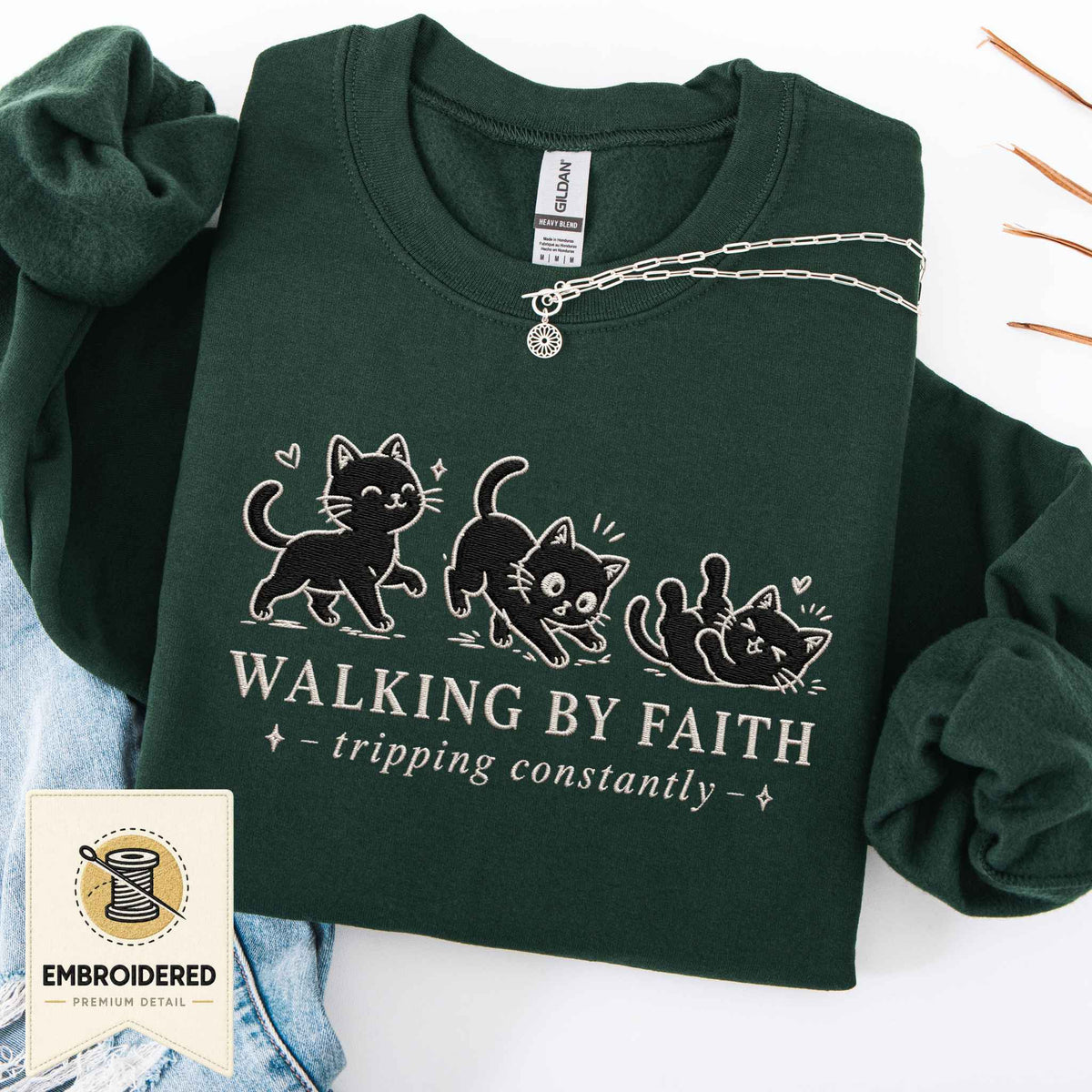 Forest green embroidered cat sweatshirt with a small Walking by Faith design and walking cats, shown flat