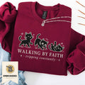 Maroon embroidered cat sweatshirt with a small Walking by Faith design and walking cats, shown flat