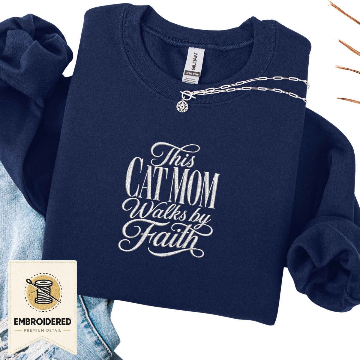 Navy embroidered cat sweatshirt with a This Cat Mom Walks by Faith script design, shown flat