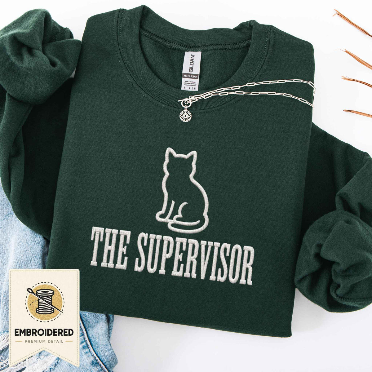 Forest green embroidered cat sweatshirt with a small cat and The Supervisor chest design, shown flat