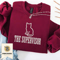 Maroon embroidered cat sweatshirt with a small cat and The Supervisor chest design, shown flat