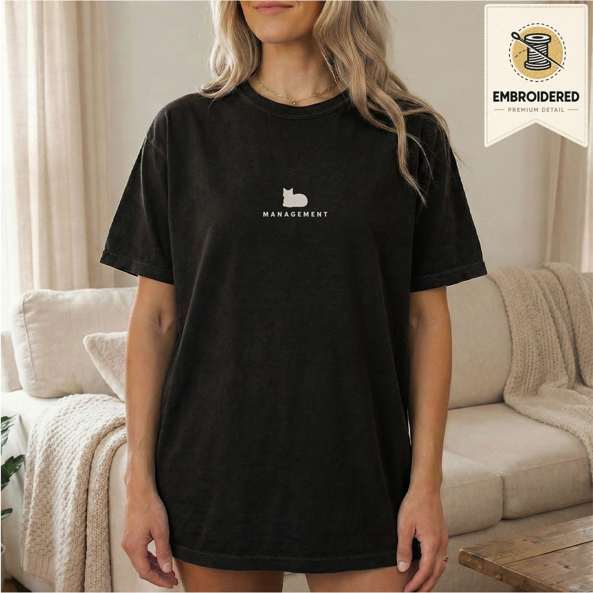 Woman wearing a black embroidered Management cat t-shirt
