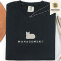Black embroidered cat t-shirt with a small cat and Management chest design, shown flat