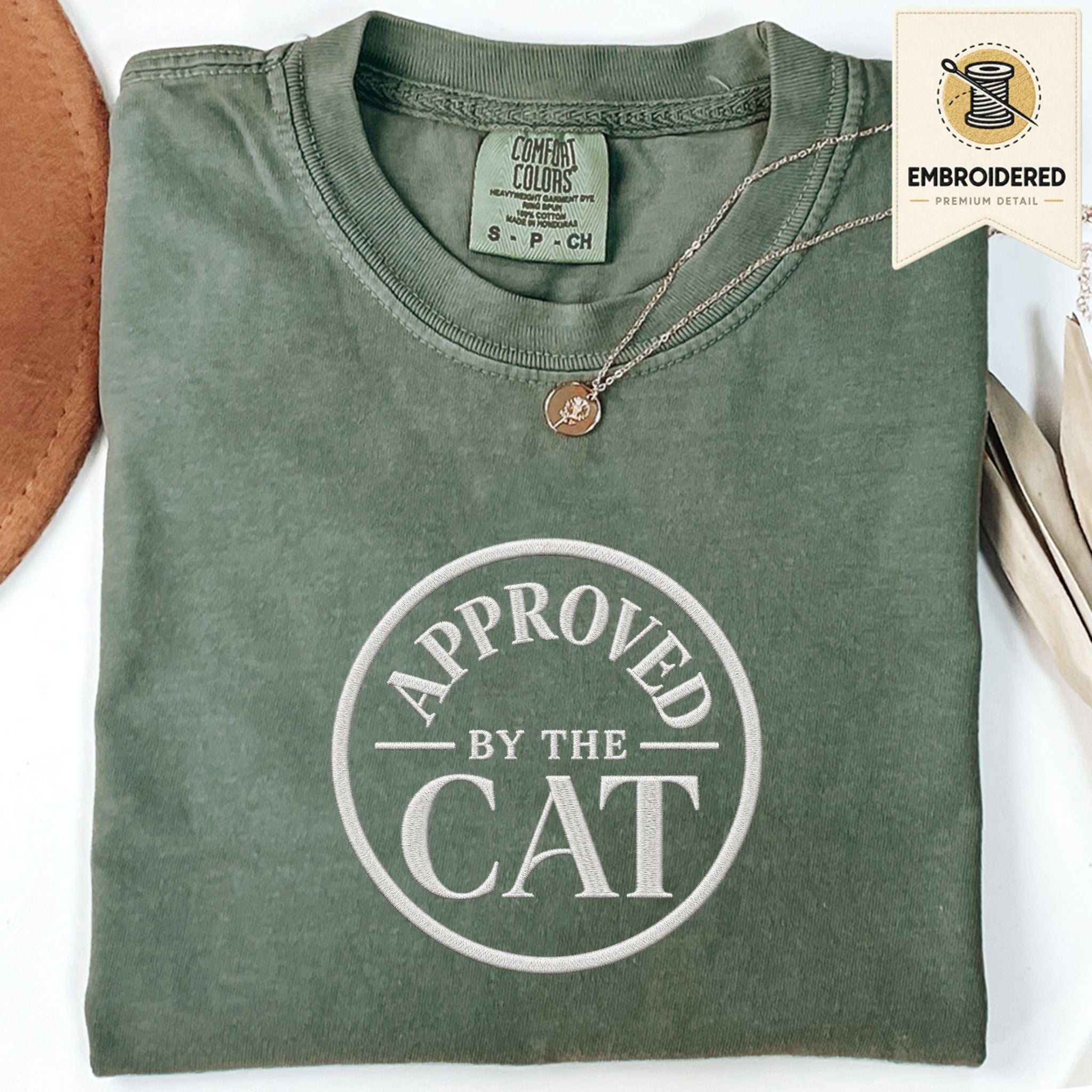 Moss green embroidered cat t-shirt with a small Approved by the Cat seal chest design, shown flat