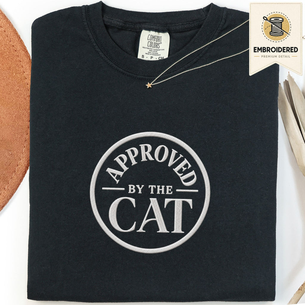 Black embroidered cat t-shirt with a small Approved by the Cat seal chest design, shown flat