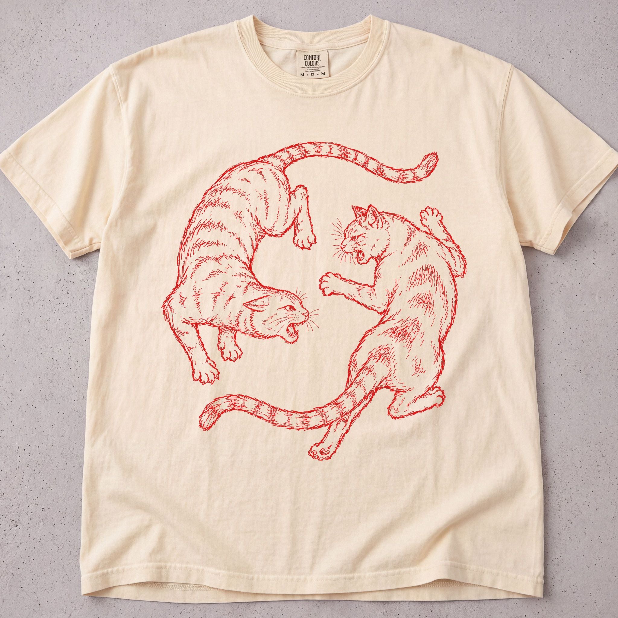 Ivory cat t-shirt with two cats play-fighting in red line art, funny cat lover tee on soft Comfort Colors cotton, flat lay front view