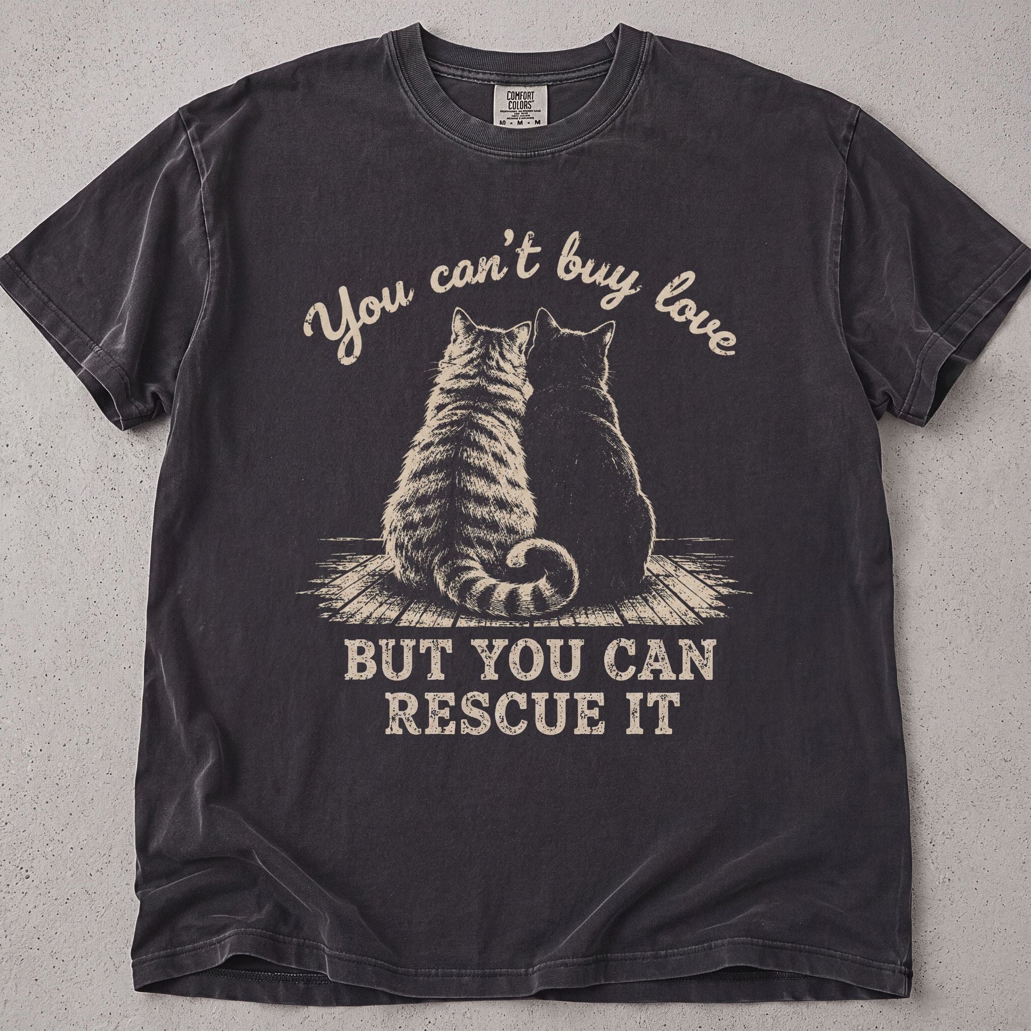 Pepper brown cat t-shirt with a cat illustration and You Can't Buy Love But You Can Rescue It text, cat lover tee on soft Comfort Colors cotton, flat lay front view