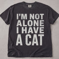 Pepper brown cat t-shirt with I'm Not Alone I Have A Cat printed text graphic, funny cat lover tee on soft Comfort Colors cotton, flat lay front view