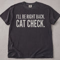 Pepper brown cat t-shirt with I'll Be Right Back Cat Check printed text graphic, funny cat lover tee on soft Comfort Colors cotton, flat lay front view