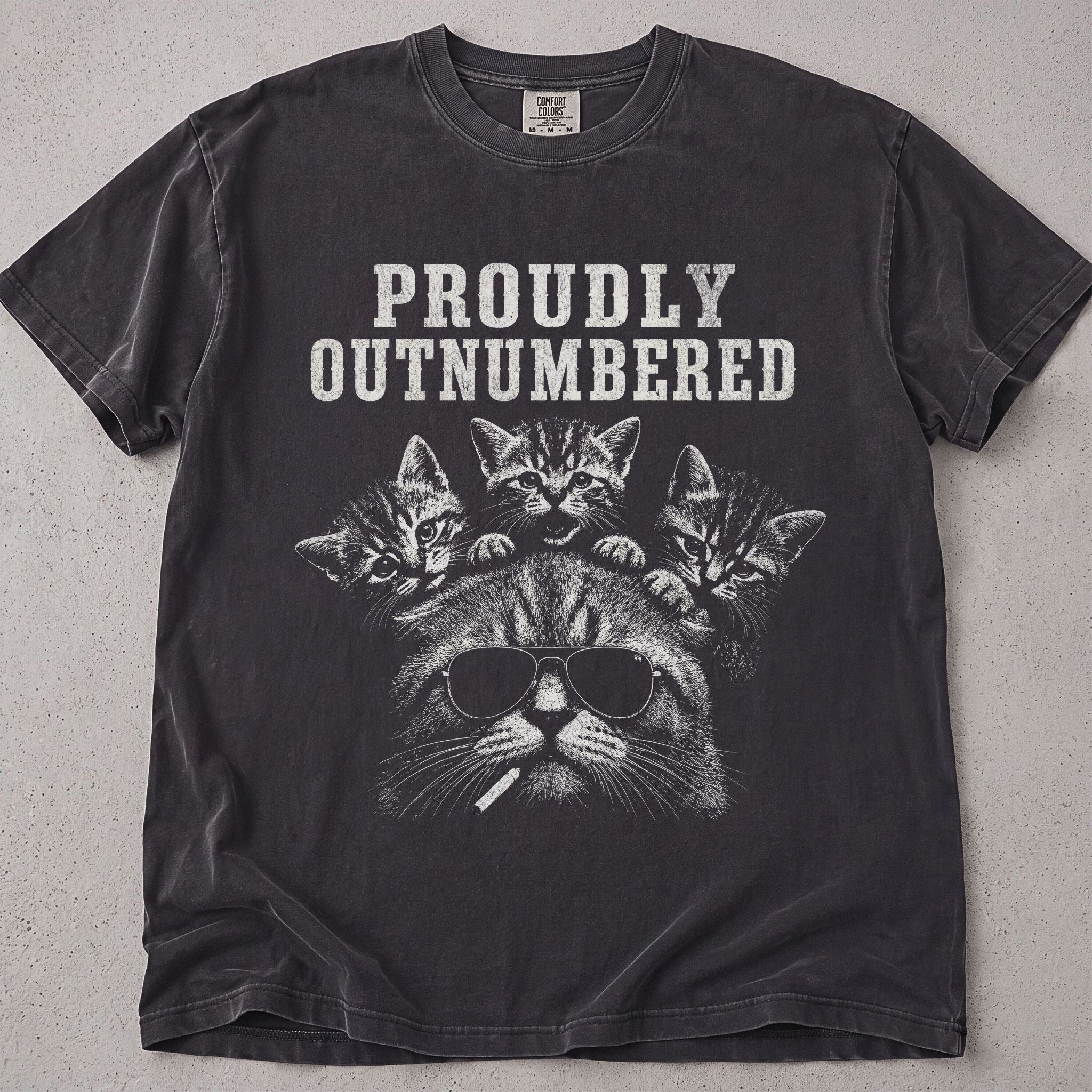 Pepper brown cat t-shirt with a cat and kittens Proudly Outnumbered graphic, funny cat lover tee on soft Comfort Colors cotton, flat lay front view