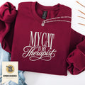 Maroon embroidered My Cat Is My Therapist sweatshirt with cursive stitched design, cozy cat lover crewneck, flat lay front view