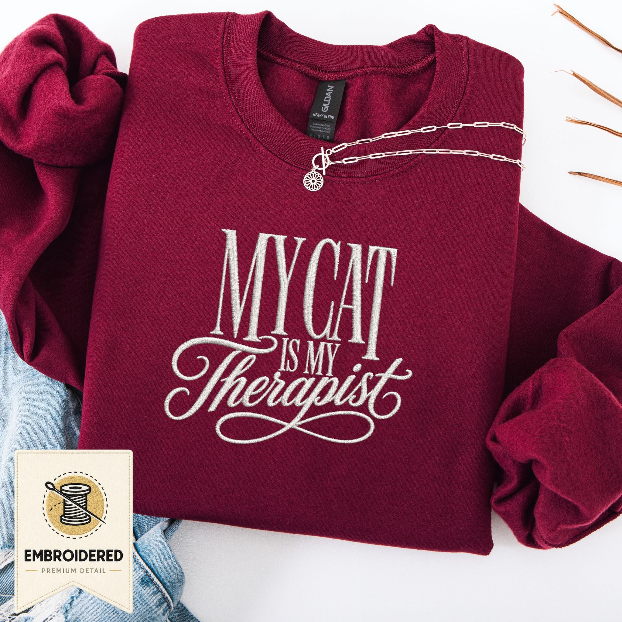 Maroon embroidered My Cat Is My Therapist sweatshirt with cursive stitched design, cozy cat lover crewneck, flat lay front view
