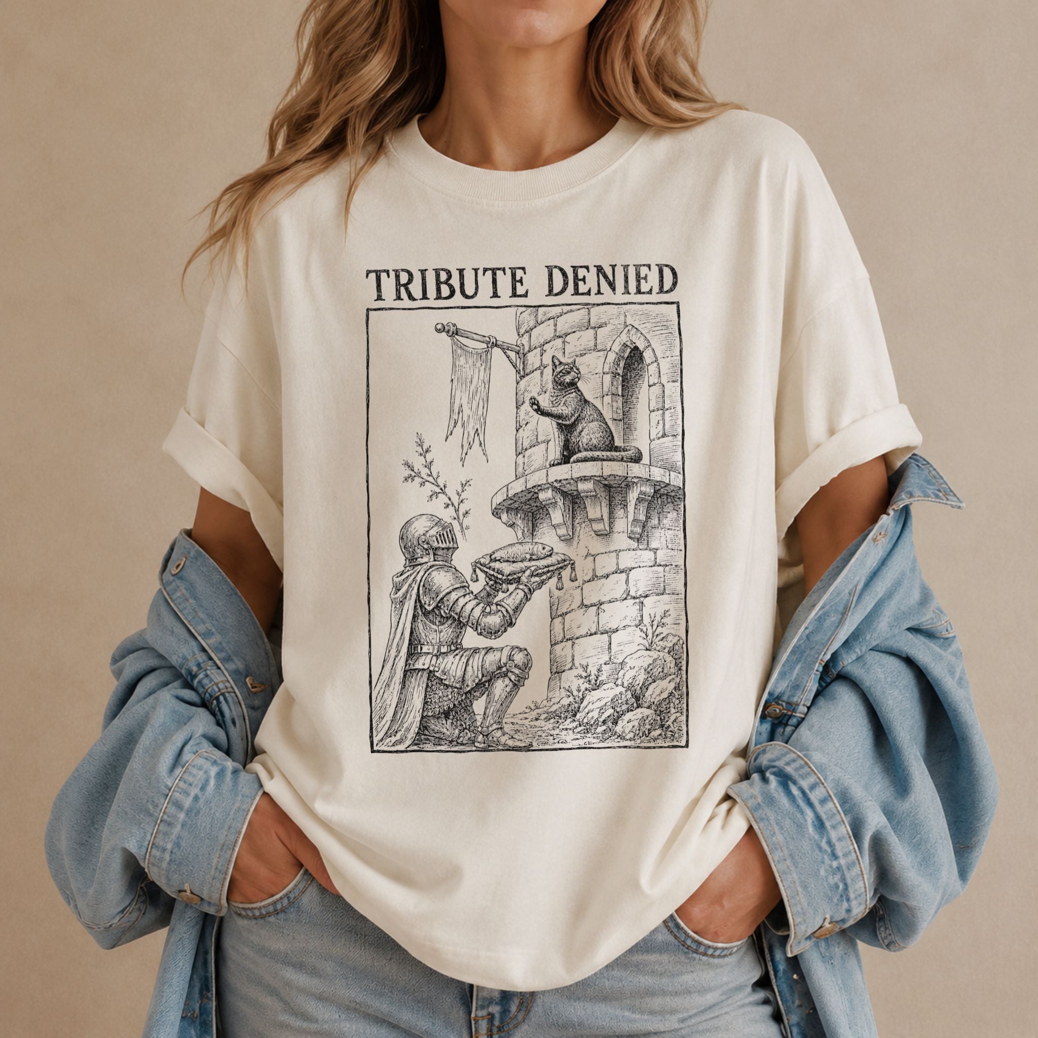 Woman wearing an ivory Tribute Denied t-shirt with a vintage medieval cat graphic