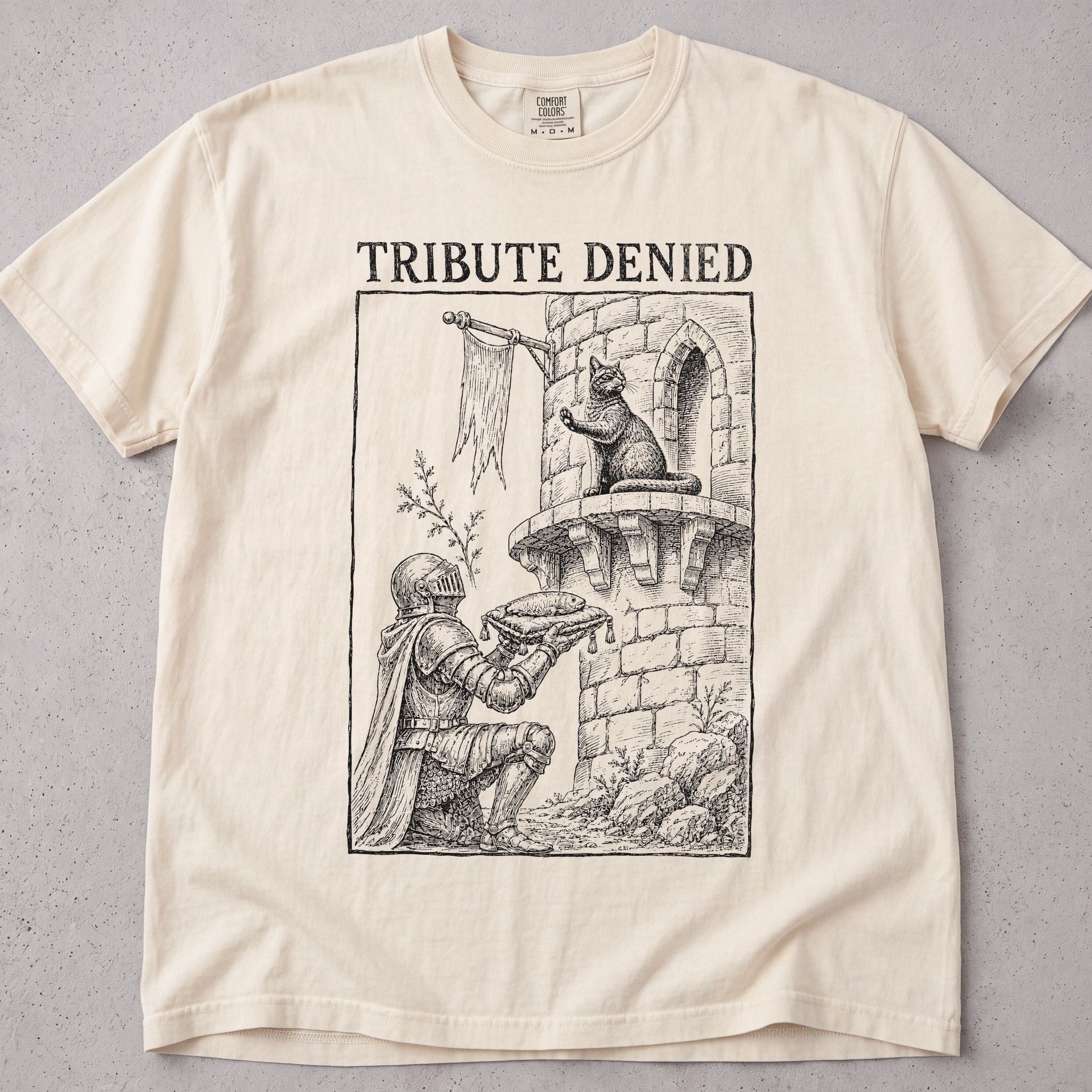 Ivory cat t-shirt with a medieval castle cat illustration and Tribute Denied text