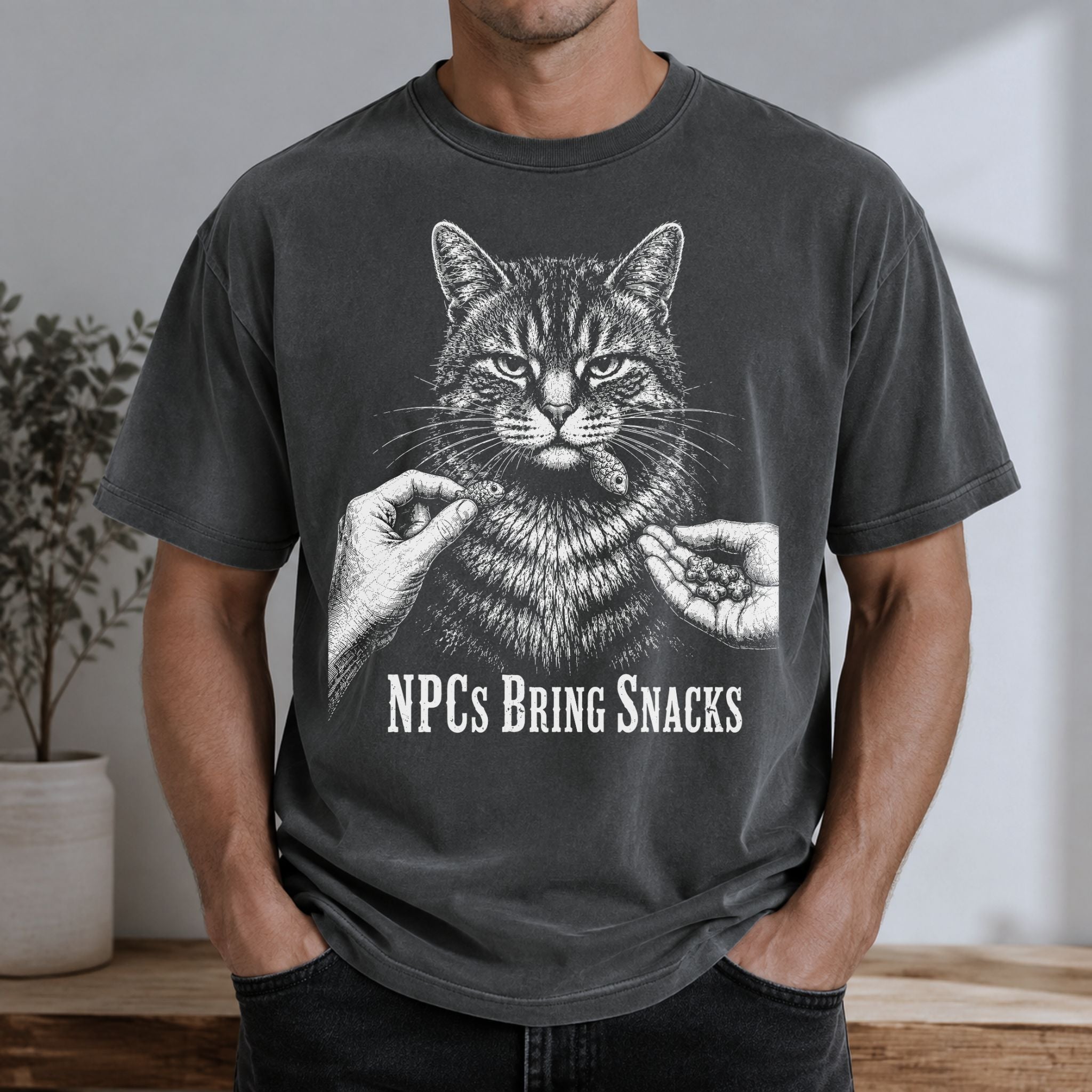 Man wearing a Pepper NPCs Bring Snacks t-shirt with a tabby cat and treat graphic